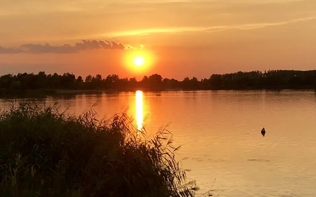 Sonnenuntergang über einem See im Spätsommer