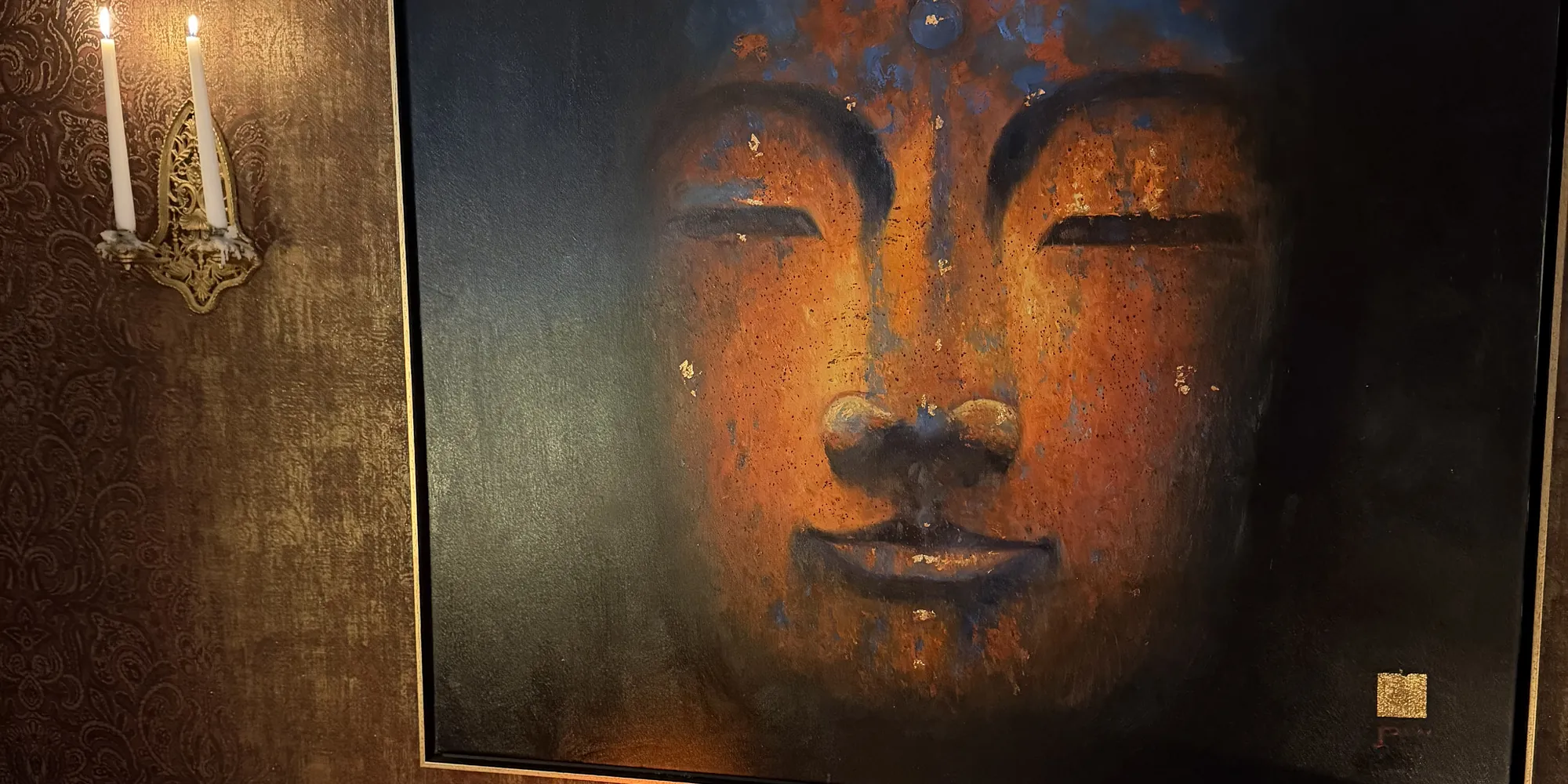 Buddha-Bild über einem Tisch mit Kerzen