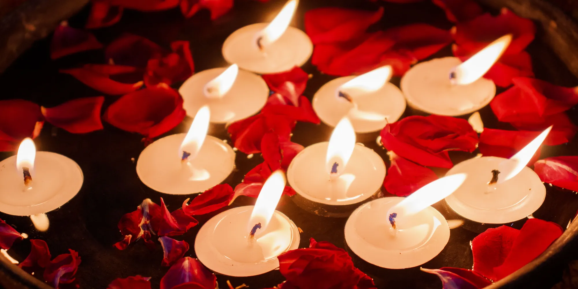 Schwimmende Kerzen zwischen Rosenblüten
