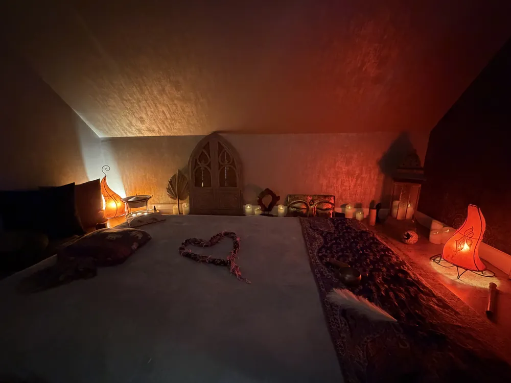 Blick in den Massageraum mit Teppichen und Kerzen