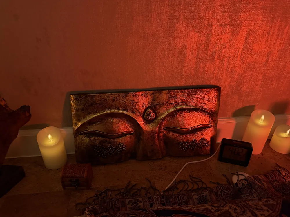 Geschnitzte Buddha-Augen zwischen Kerzen