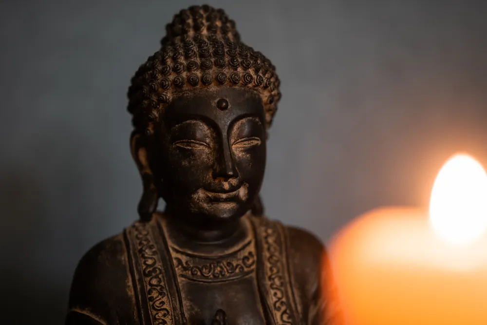 Buddha-Büste neben einer Kerze